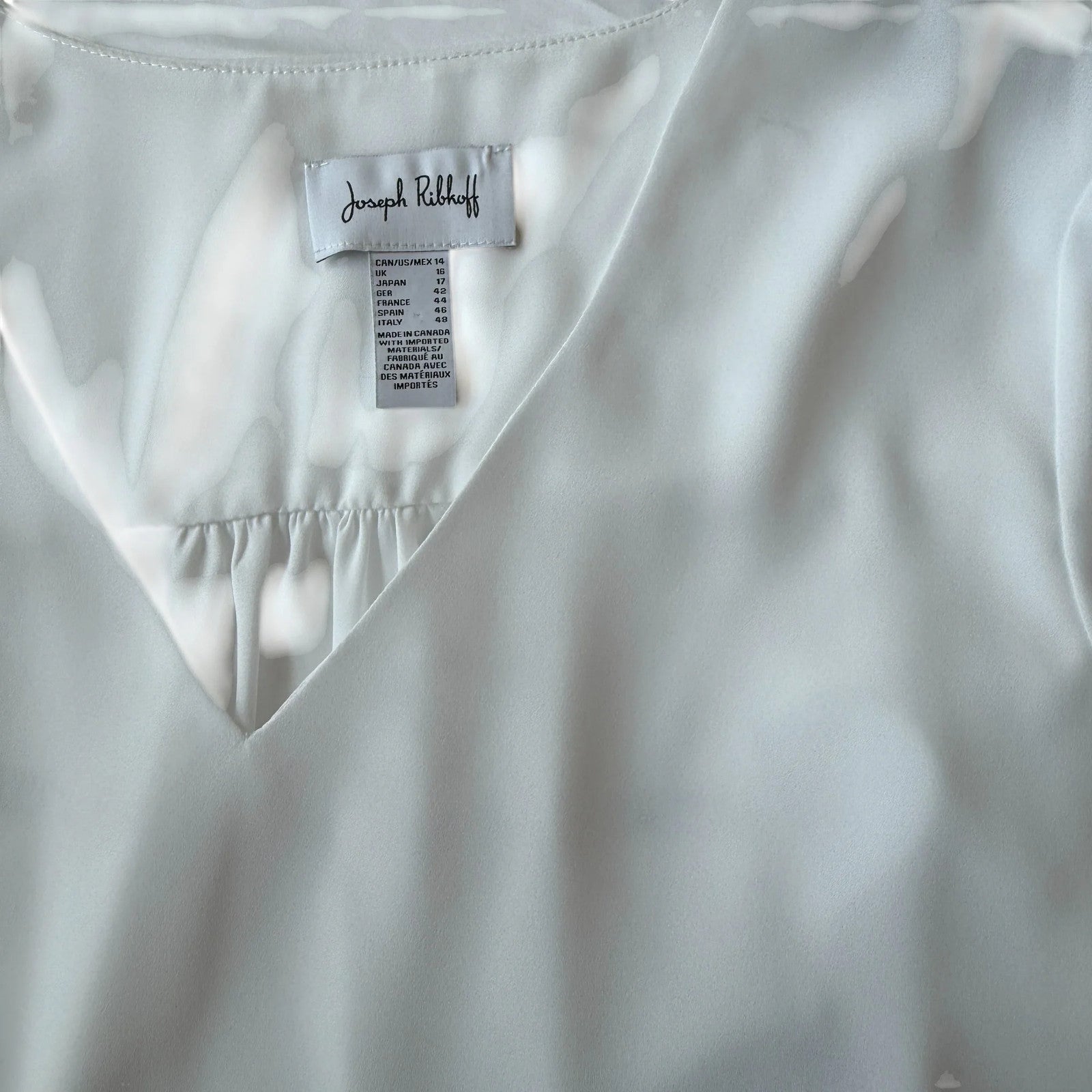 Joseph Ribkoff white chiffon with ruffled sleeves and asymetric hem tunic.
